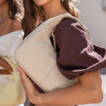 Cartera de cuero Cala Cream en beige crema, llevada al hombro