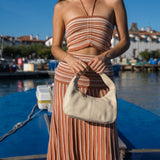 Cartera de cuero Cala Cream en beige crema, combinada con un look a rayas
